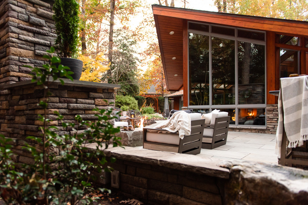 Immagine di un patio o portico classico di medie dimensioni e dietro casa con un caminetto e pavimentazioni in pietra naturale