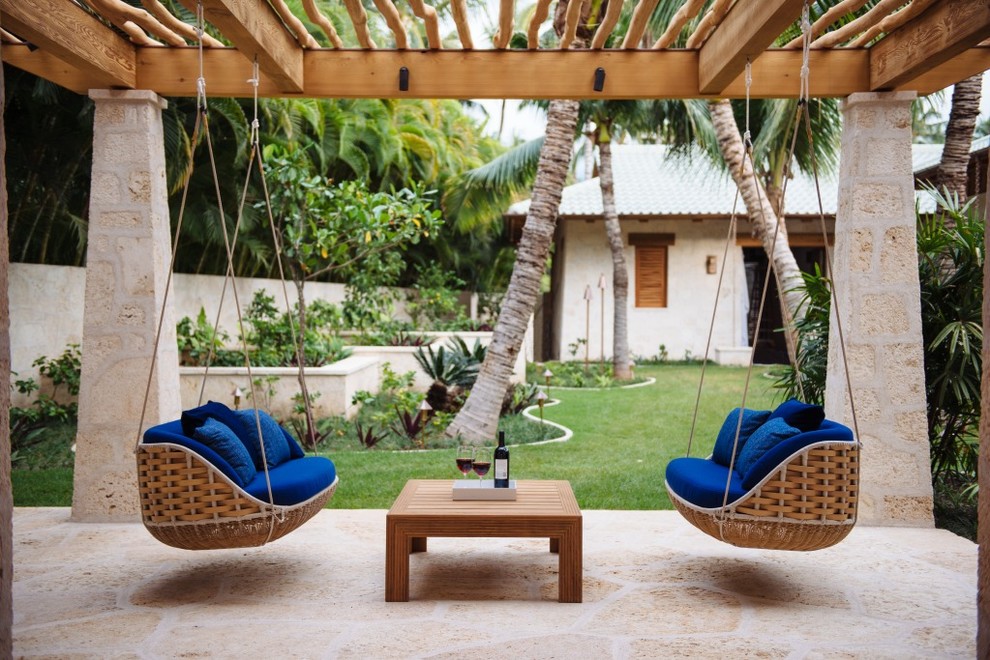 Mittelgroße Pergola hinter dem Haus mit Natursteinplatten und Kübelpflanzen in Hawaii