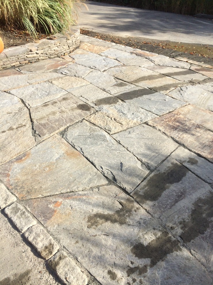 Example of a mid-sized classic backyard stone patio design in New York with no cover