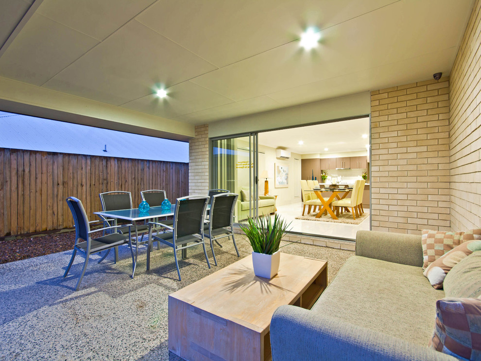 Example of a mid-sized minimalist backyard patio design in Brisbane with a roof extension
