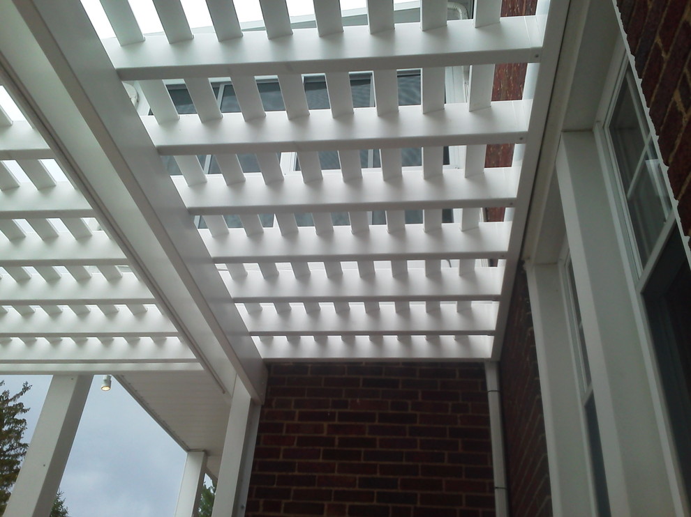 This is an example of a large modern back patio in Cleveland with tiled flooring and a pergola.