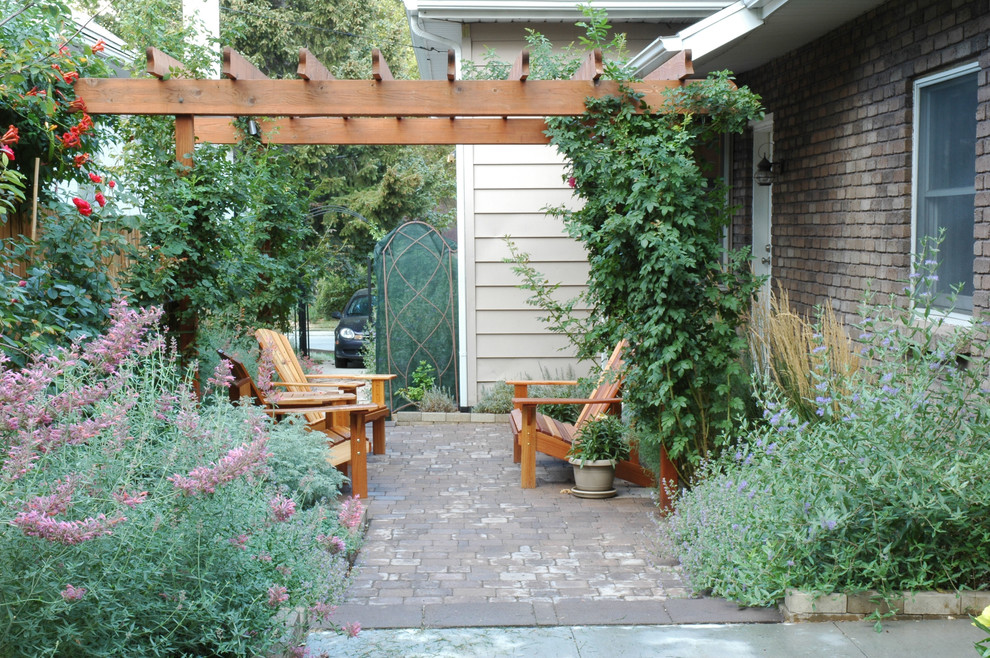 Immagine di un patio o portico chic dietro casa e di medie dimensioni con una pergola e pavimentazioni in cemento