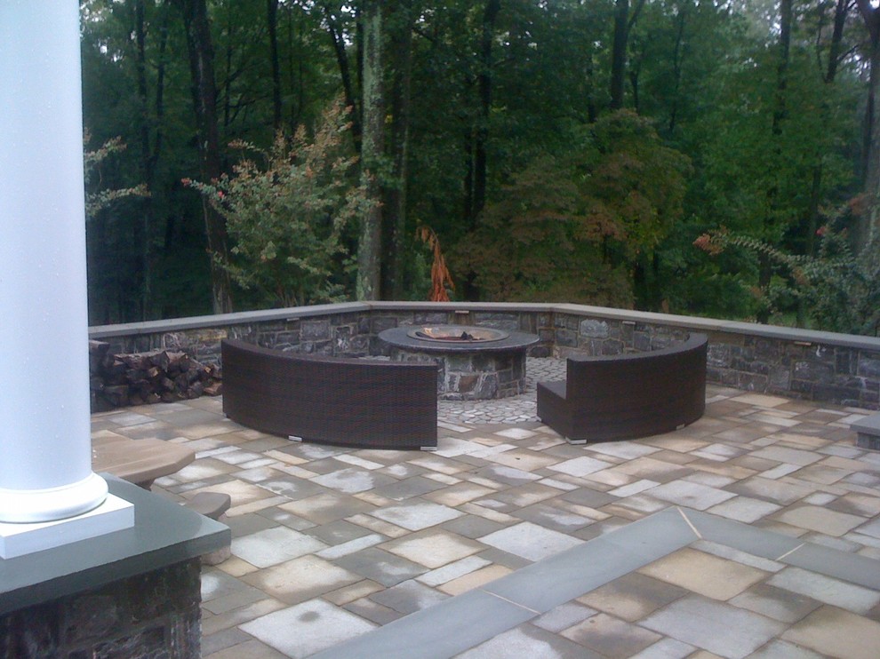 Immagine di un grande patio o portico chic dietro casa con un focolare, pavimentazioni in pietra naturale e una pergola