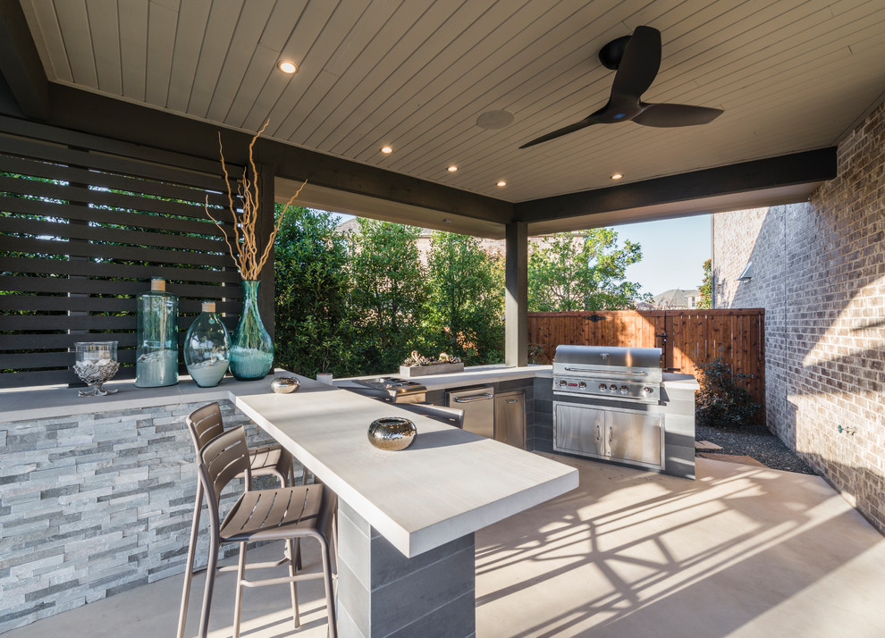 Large modern back patio in Dallas with an outdoor kitchen, concrete slabs and a roof extension.