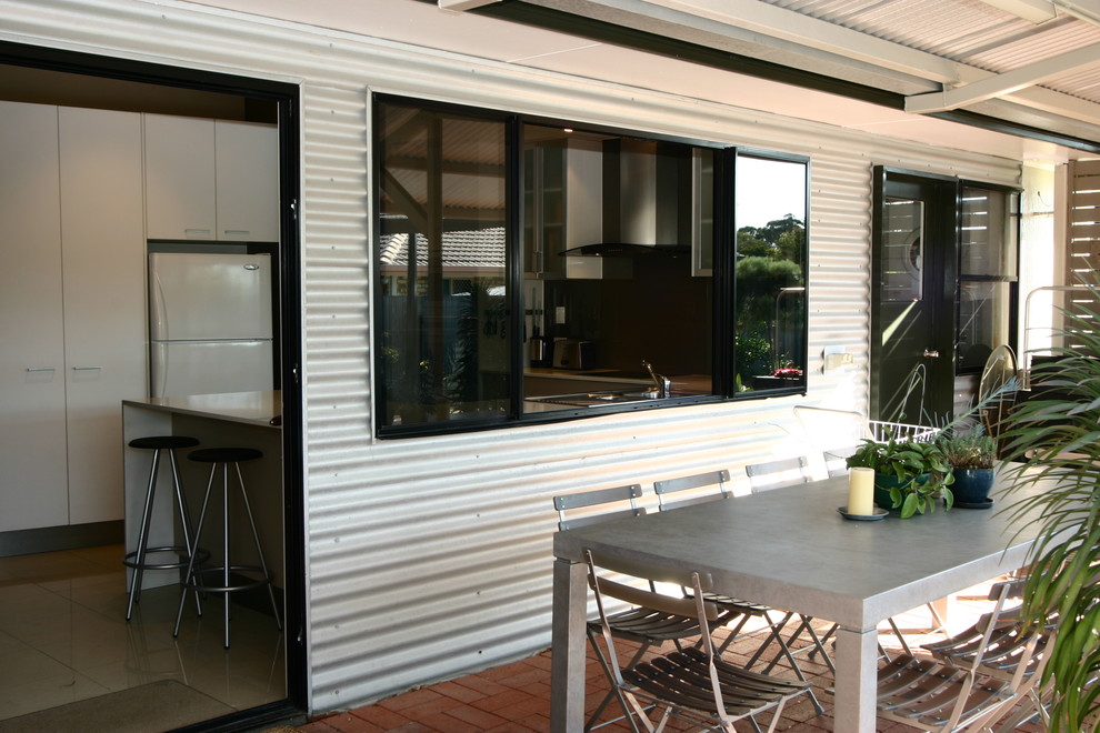 Пример оригинального дизайна: двор в современном стиле с мощением клинкерной брусчаткой и навесом