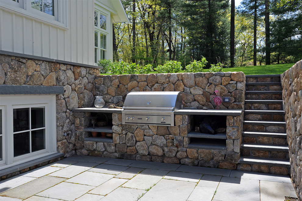 Aménagement d'une terrasse arrière contemporaine de taille moyenne avec une cuisine d'été, des pavés en pierre naturelle et aucune couverture.