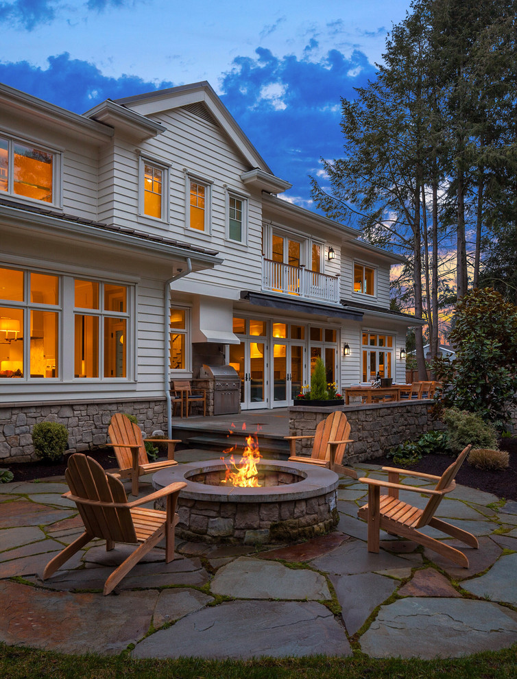 Klassischer Patio hinter dem Haus mit Feuerstelle und Natursteinplatten in Seattle