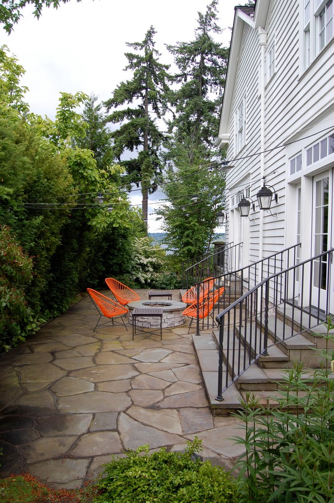 На фото: двор в современном стиле с местом для костра с