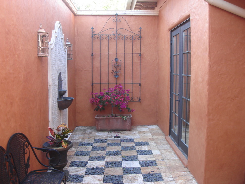 Стильный дизайн: маленький двор на внутреннем дворе в средиземноморском стиле с фонтаном и покрытием из плитки без защиты от солнца для на участке и в саду - последний тренд