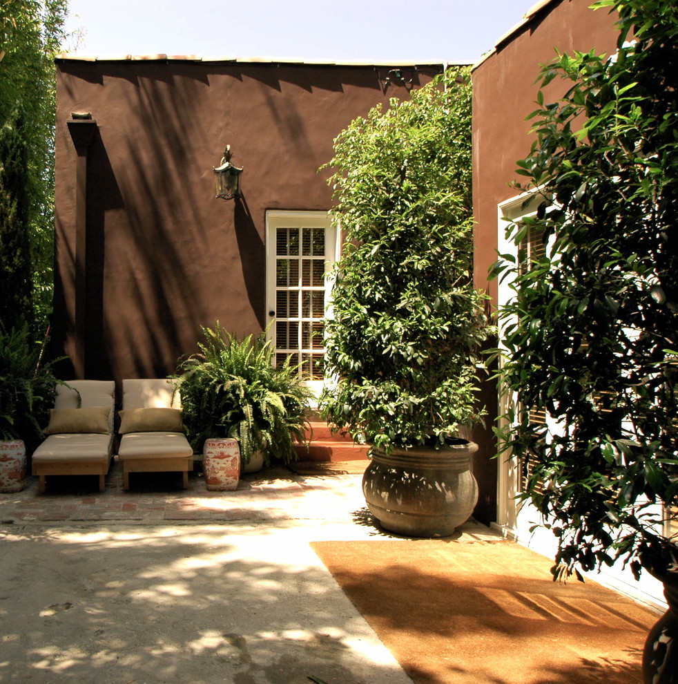 Esempio di un patio o portico mediterraneo con pavimentazioni in cemento, nessuna copertura e scale