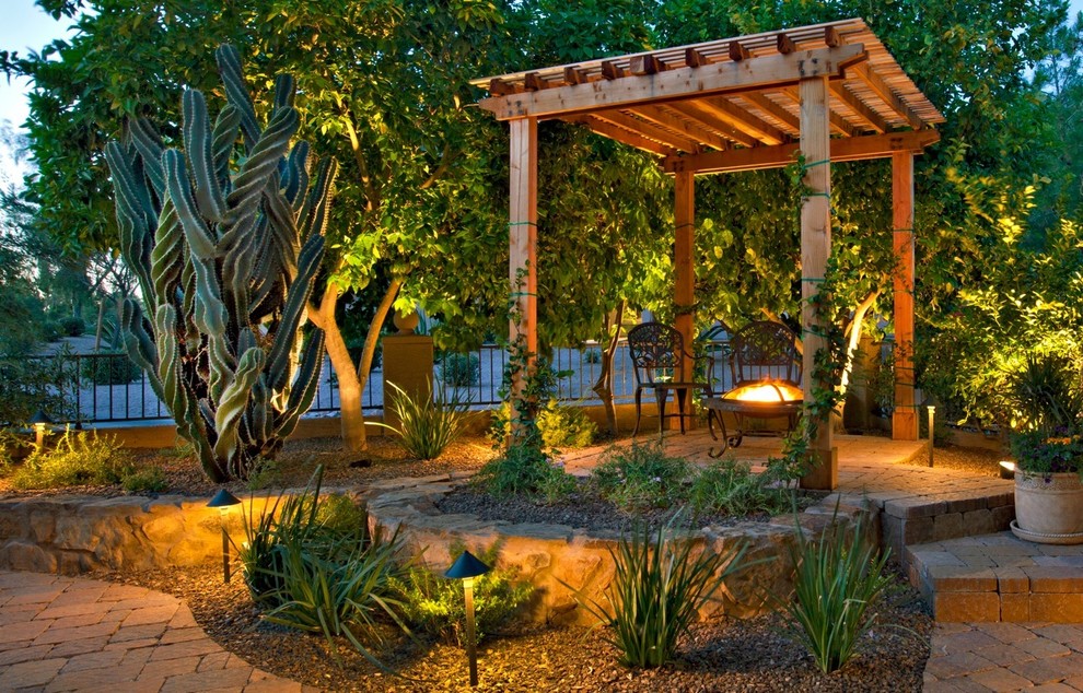 Immagine di un patio o portico mediterraneo in cortile con un focolare e una pergola