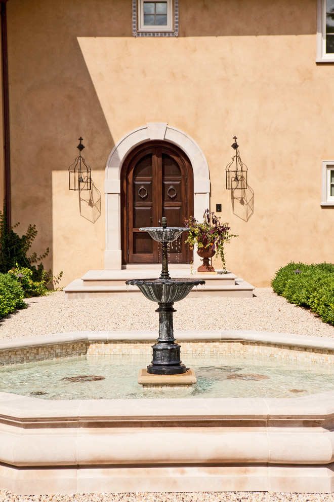 Medium sized mediterranean courtyard patio in New York with a water feature, gravel and no cover.