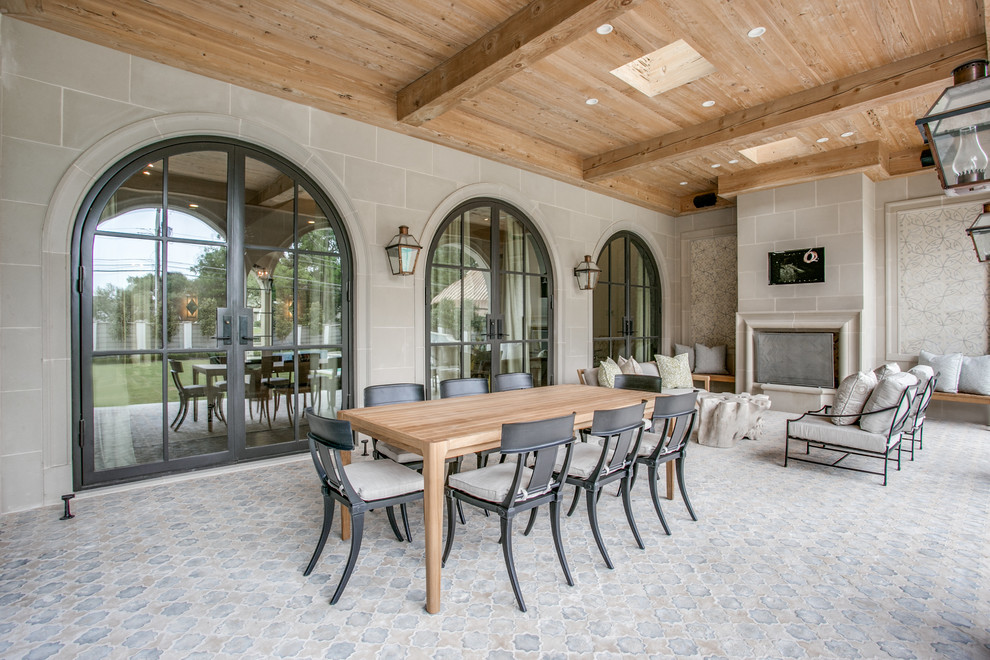 Huge tuscan backyard stone patio photo in Dallas with a roof extension