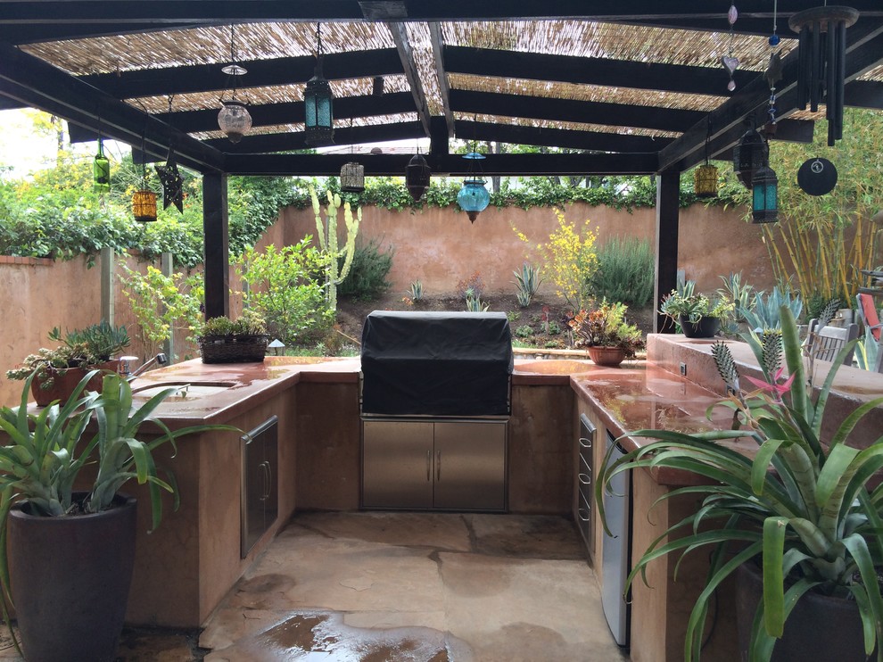 Example of a mid-sized tuscan backyard stone patio kitchen design in Los Angeles with a gazebo