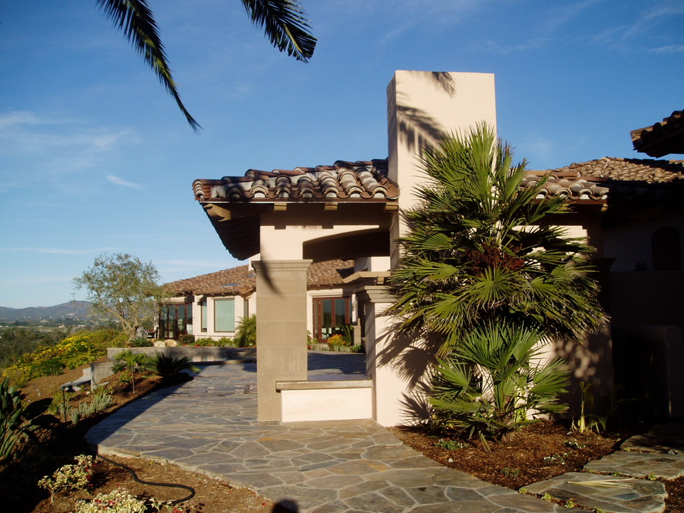 Mediterraner Patio hinter dem Haus mit Natursteinplatten in San Diego