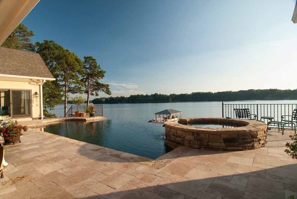 Photo of a mediterranean back swimming pool in Charlotte with a water feature and natural stone paving.