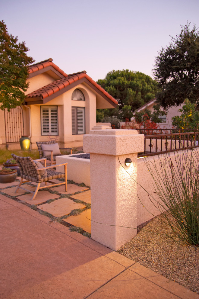 Immagine di un grande patio o portico mediterraneo in cortile con un focolare e pavimentazioni in pietra naturale