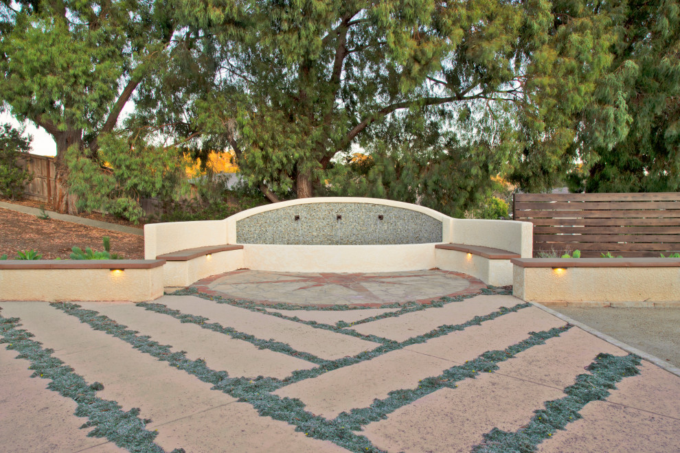 Idee per un grande patio o portico mediterraneo dietro casa con fontane e lastre di cemento