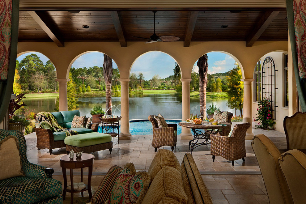 Example of a large tuscan backyard tile patio design in Orlando with a fire pit and a roof extension