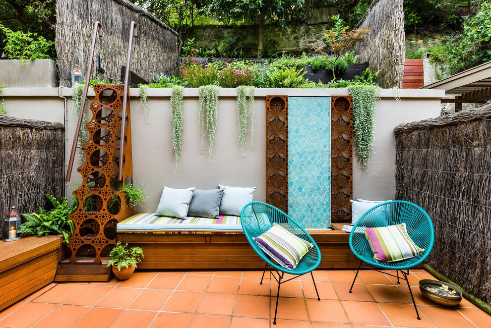 На фото: маленький двор в средиземноморском стиле с покрытием из плитки без защиты от солнца для на участке и в саду