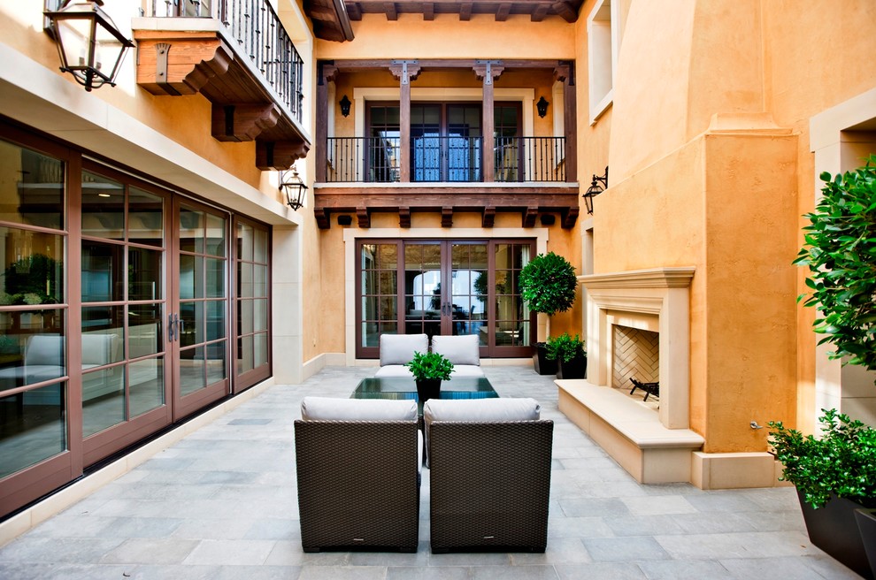 Example of a tuscan patio design in Orange County with a fire pit