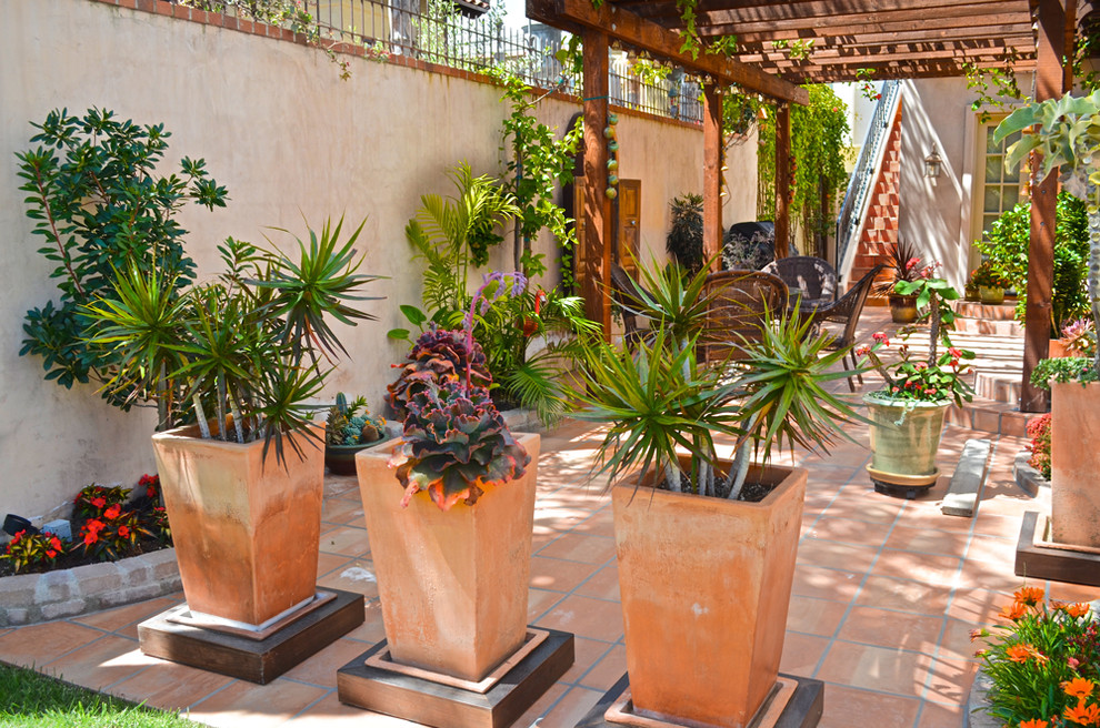 Example of a tuscan tile patio design in Los Angeles with a pergola