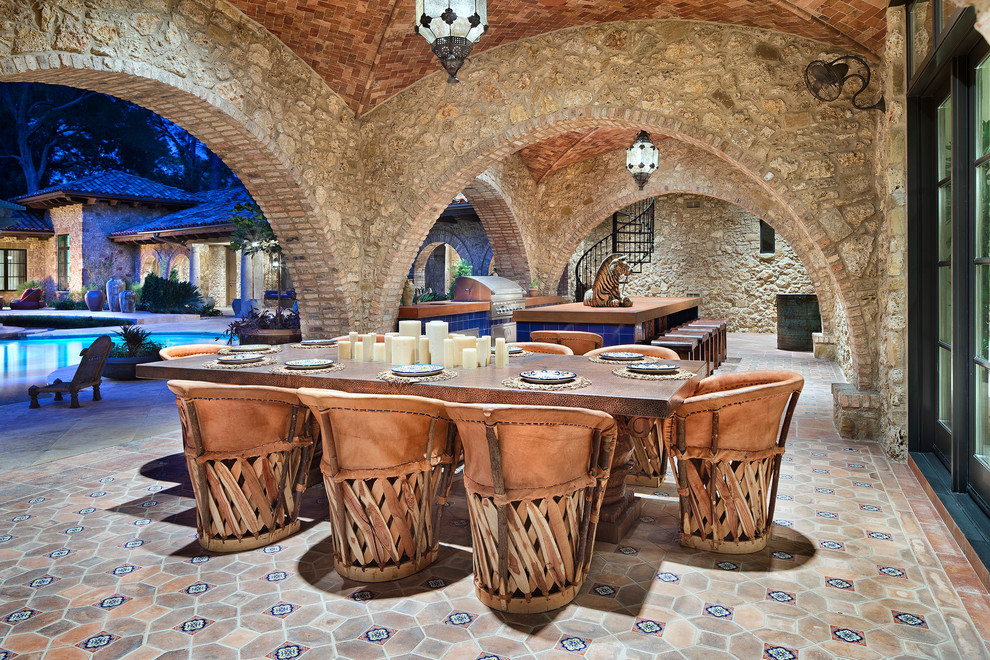 Пример оригинального дизайна: двор в средиземноморском стиле с летней кухней, покрытием из плитки и навесом