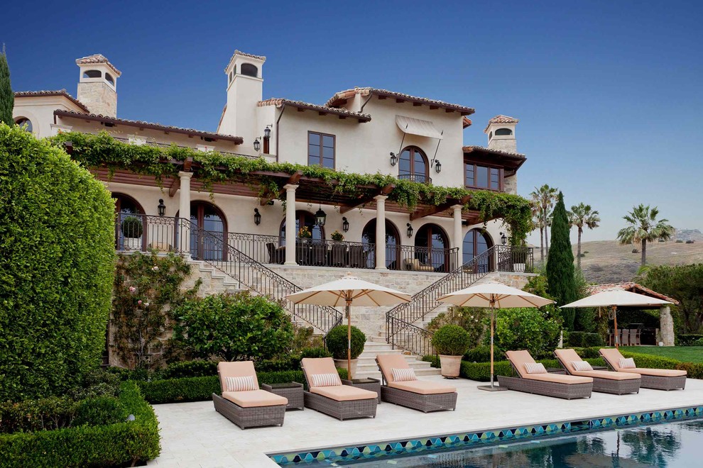 Foto di un ampio patio o portico mediterraneo dietro casa con fontane e una pergola
