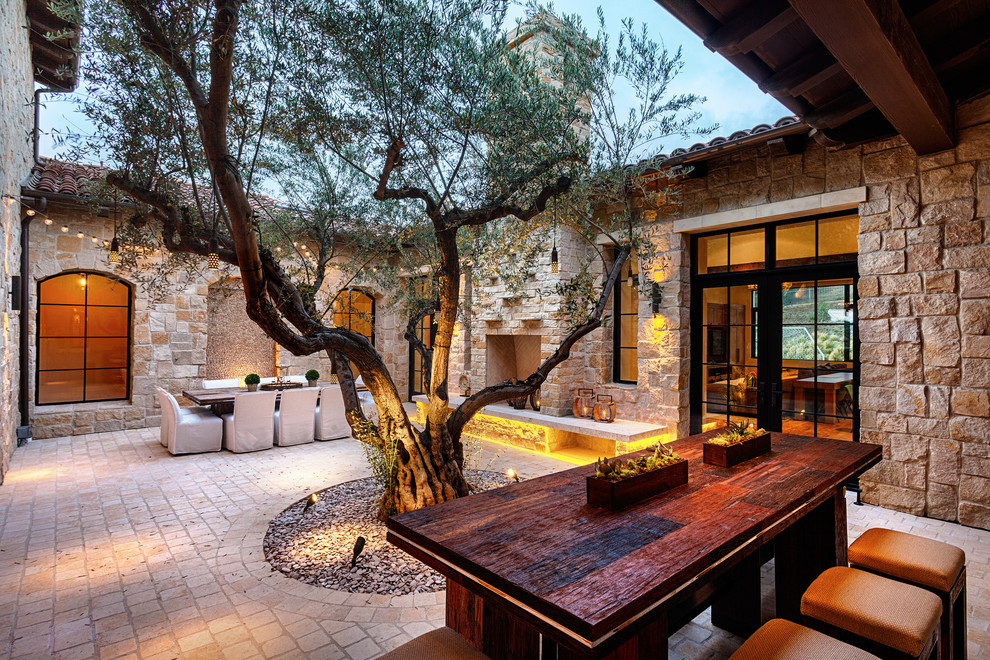 Cette image montre une terrasse méditerranéenne avec une cour et un foyer extérieur.