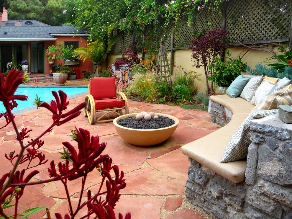 Mid-sized tuscan backyard stone patio photo in Los Angeles with a fire pit