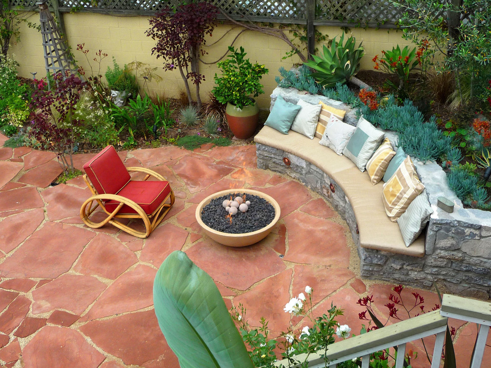 Esempio di un patio o portico mediterraneo di medie dimensioni e dietro casa con un focolare e pavimentazioni in pietra naturale