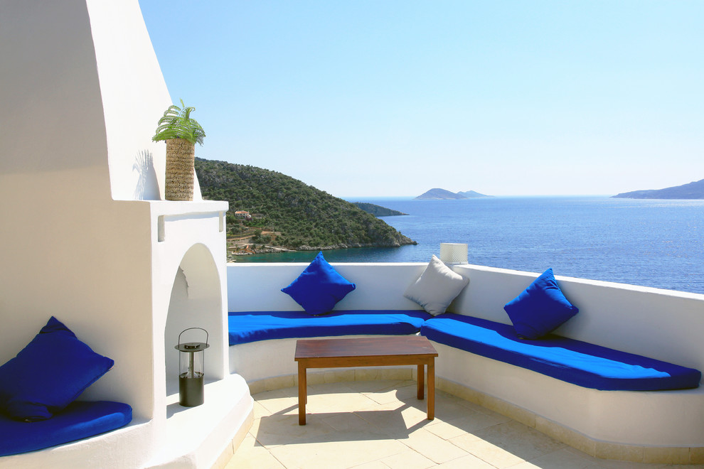 Cette photo montre une terrasse méditerranéenne avec aucune couverture et une cheminée.