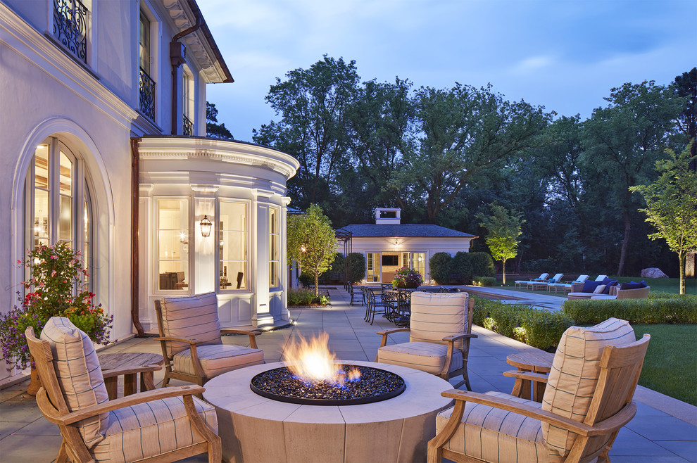 Photo of a mediterranean back patio in Minneapolis with a fire feature and natural stone paving.
