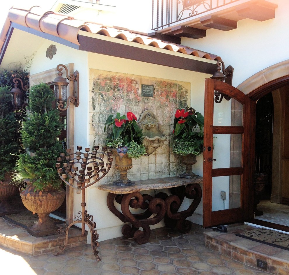 Example of a large mountain style courtyard tile patio fountain design in San Diego with no cover