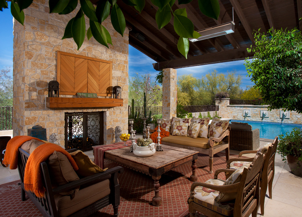 Photo of a medium sized mediterranean back patio in Phoenix with a fire feature, tiled flooring and a roof extension.