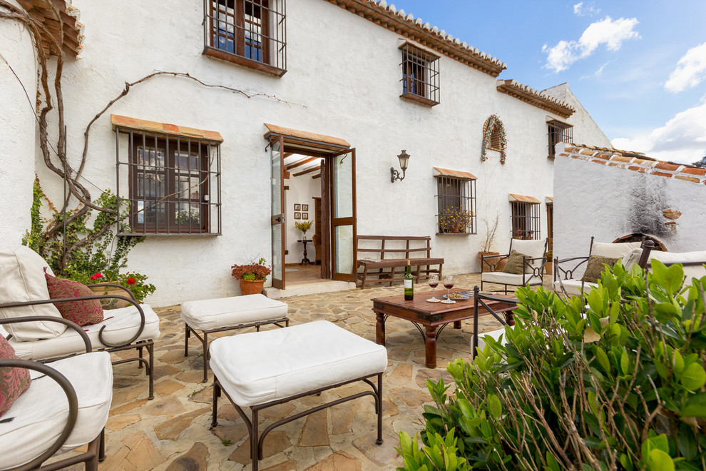 Foto di un grande patio o portico mediterraneo davanti casa con un giardino in vaso, pavimentazioni in pietra naturale e nessuna copertura