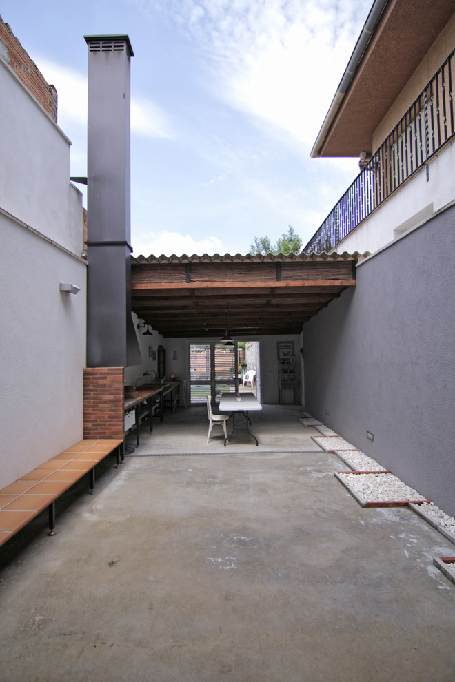 Пример оригинального дизайна: маленький двор на внутреннем дворе в средиземноморском стиле с местом для костра и покрытием из декоративного бетона для на участке и в саду