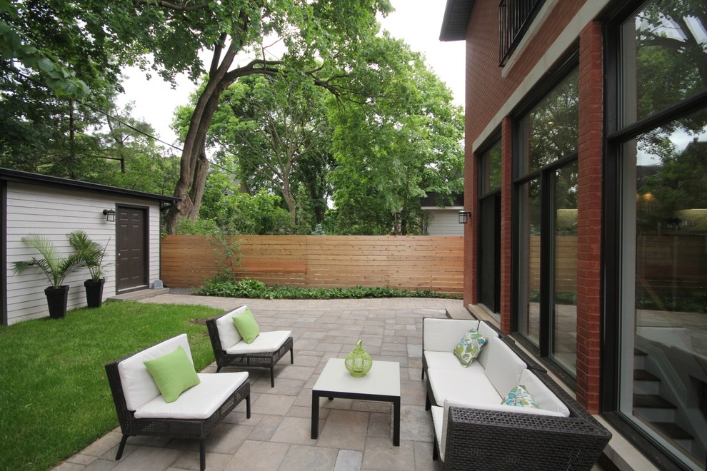 Mid-sized transitional backyard concrete paver patio photo in Ottawa with no cover