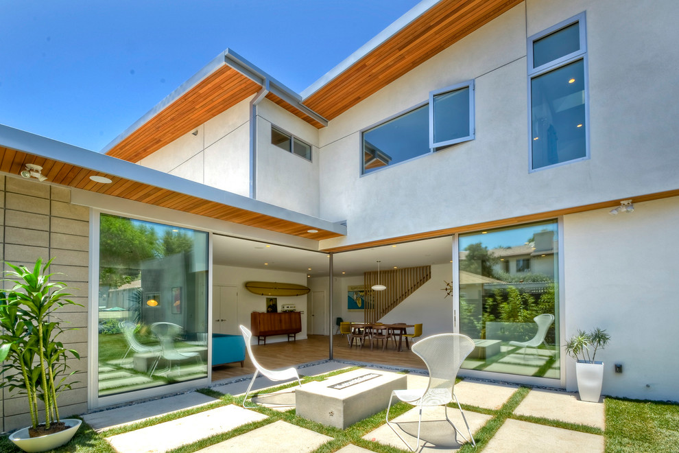 Mid-century modern patio photo in San Diego with a fire pit and no cover