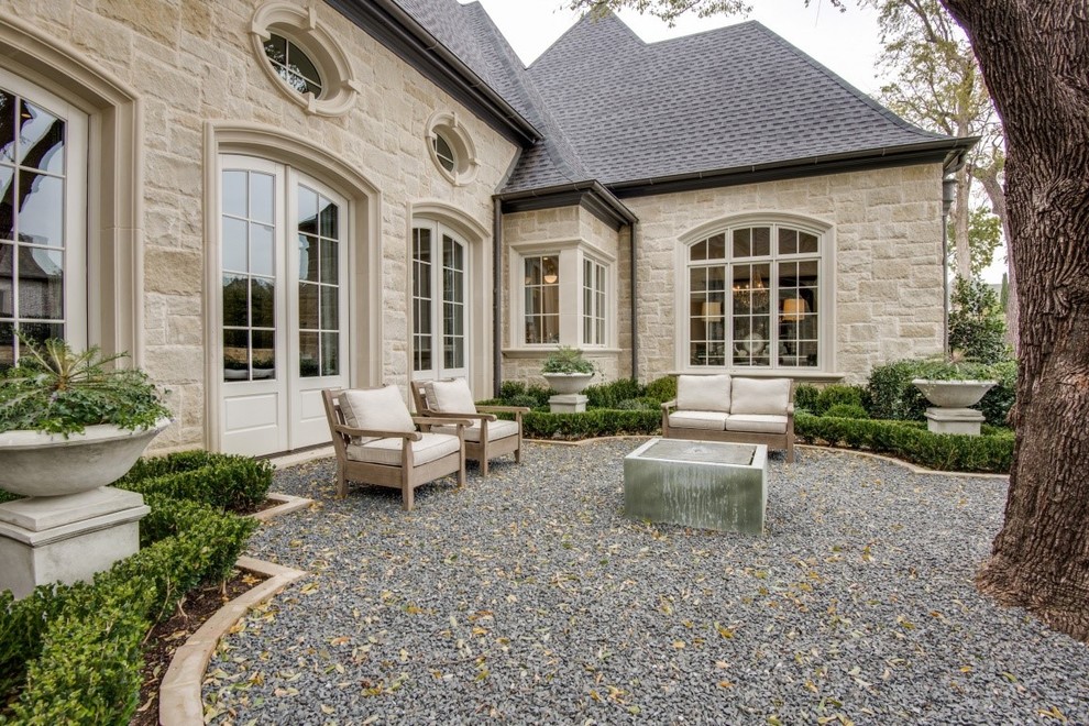 Photo of a large traditional front patio in Dallas with gravel and no cover.