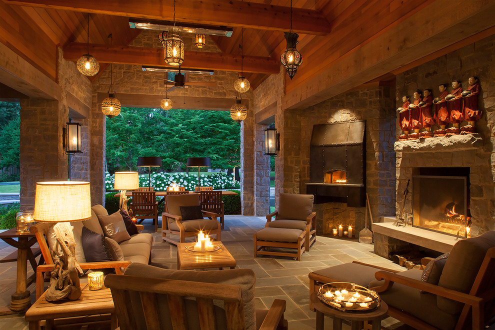 Example of a large classic stone patio design in Other with a fireplace