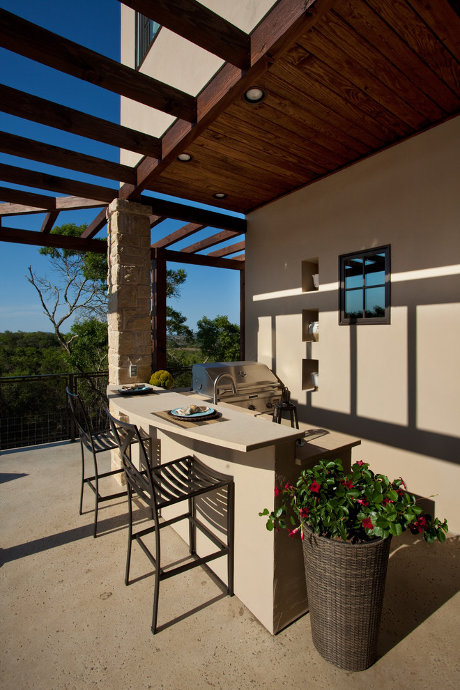 Réalisation d'une terrasse tradition avec une cuisine d'été, une dalle de béton et une extension de toiture.