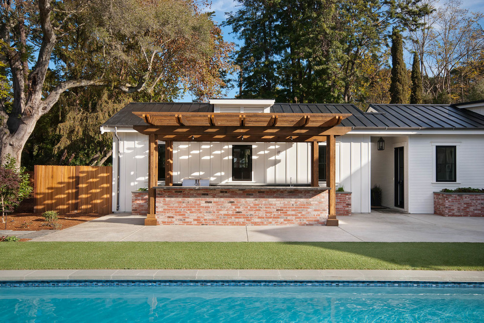 Mid-sized cottage backyard concrete patio kitchen photo in San Francisco with a pergola