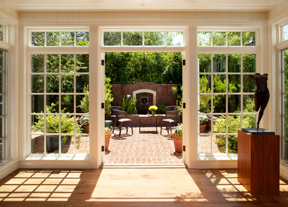 Foto de patio clásico de tamaño medio sin cubierta en patio lateral con fuente y adoquines de ladrillo