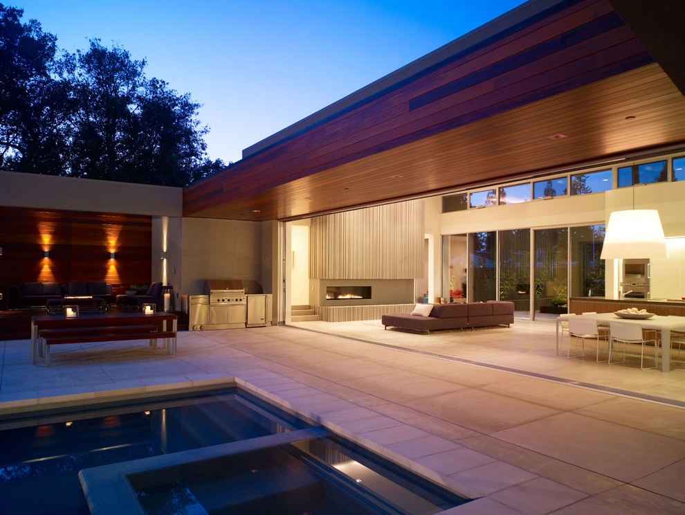 Exemple d'une terrasse latérale tendance avec une cuisine d'été, des pavés en béton et une extension de toiture.