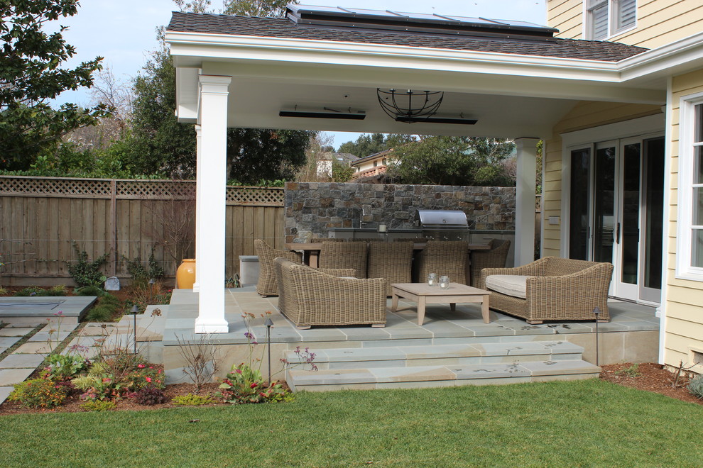 Imagen de patio clásico de tamaño medio en patio trasero y anexo de casas con cocina exterior y adoquines de piedra natural