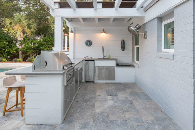Cette photo montre une terrasse arrière bord de mer avec une cuisine d'été, des pavés en pierre naturelle et un gazebo ou pavillon.