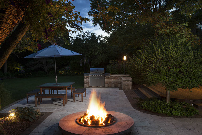 Inspiration for a large contemporary back patio in Milwaukee with a fire feature, natural stone paving and no cover.
