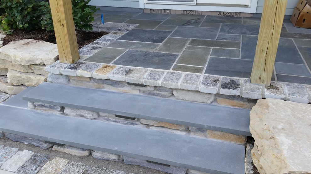 Foto di un patio o portico design dietro casa con pavimentazioni in pietra naturale