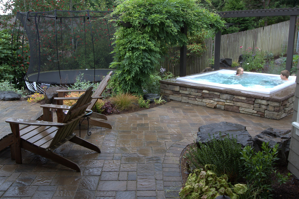 Large traditional back patio in Seattle with natural stone paving and a gazebo.